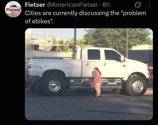 cities are currently discussing the "problem of ebikes." of a person who looks tiny compared to the massive truck beside them. 